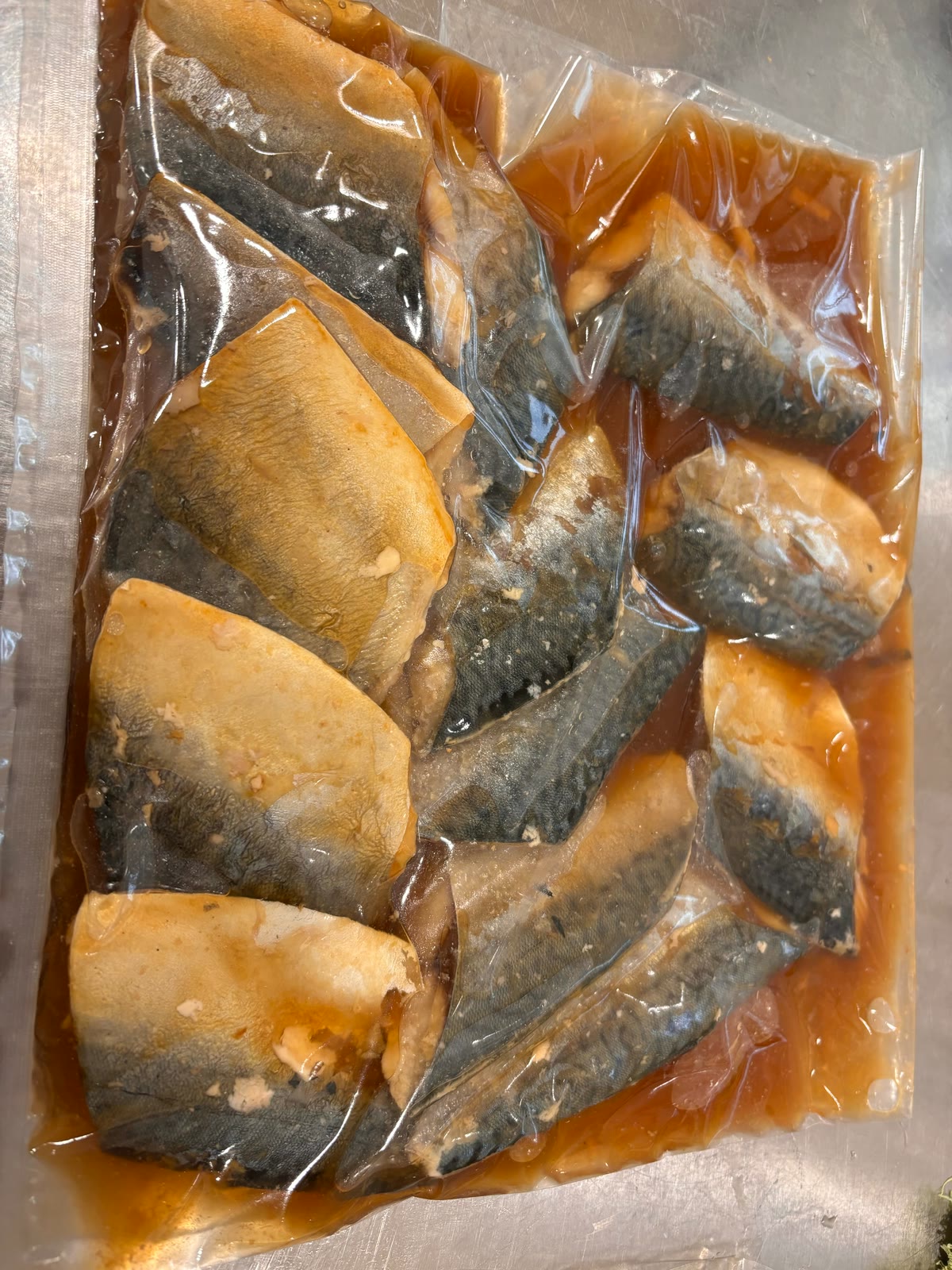 調理後の魚をたれと一緒に真空包装したようす
